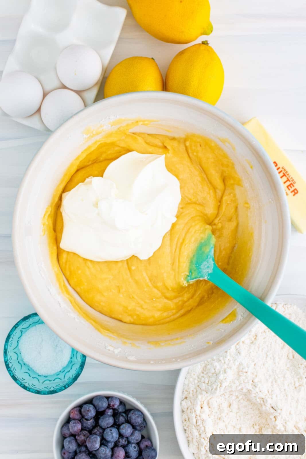 Sour cream added to mixture in bowl.