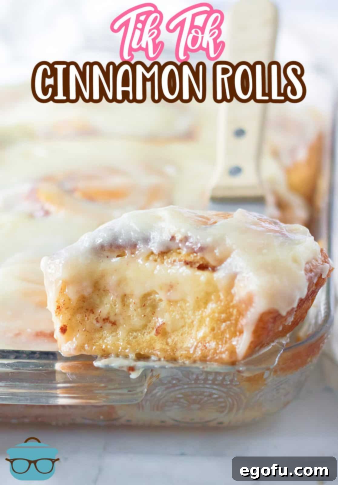 An appetizing overhead shot of baked Tik Tok Cinnamon Rolls in a pan, glistening with rich homemade icing.