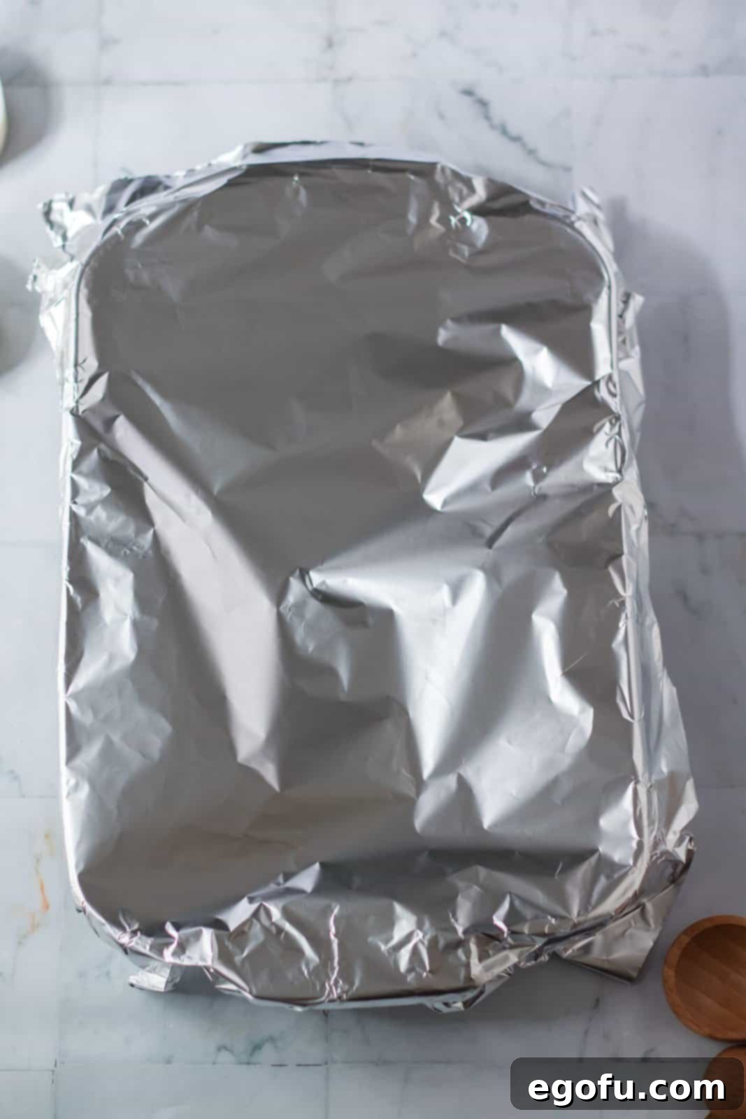 The baking dish covered tightly with aluminum foil, ready to go into the oven.