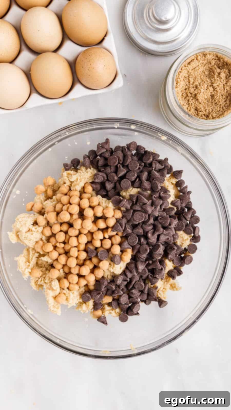 Sweet and Salty Caramel Chocolate Chip Bars 9 Chocolate chips and caramels added to dough in bowl.