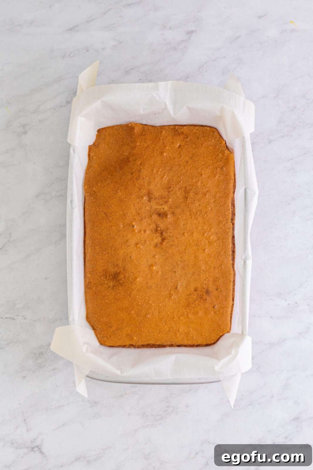 Freshly baked brownies cooling in their baking pan on a wire rack.
