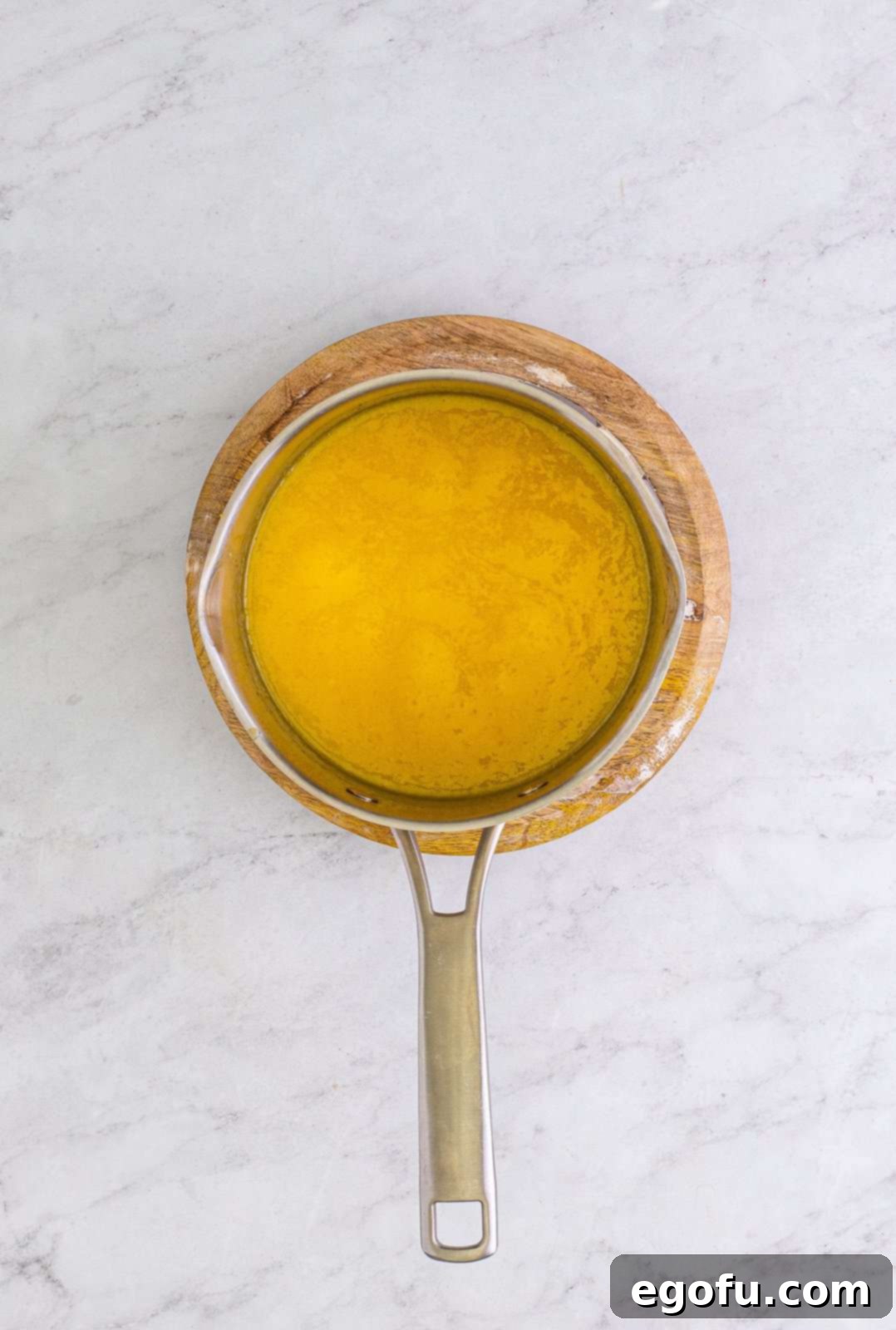 Granulated sugar, evaporated milk, butter, and egg yolks cooking together in a saucepan for the German chocolate topping.
