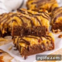Close-up square image of two stacked German Chocolate Brownies, showing their rich texture and topping.