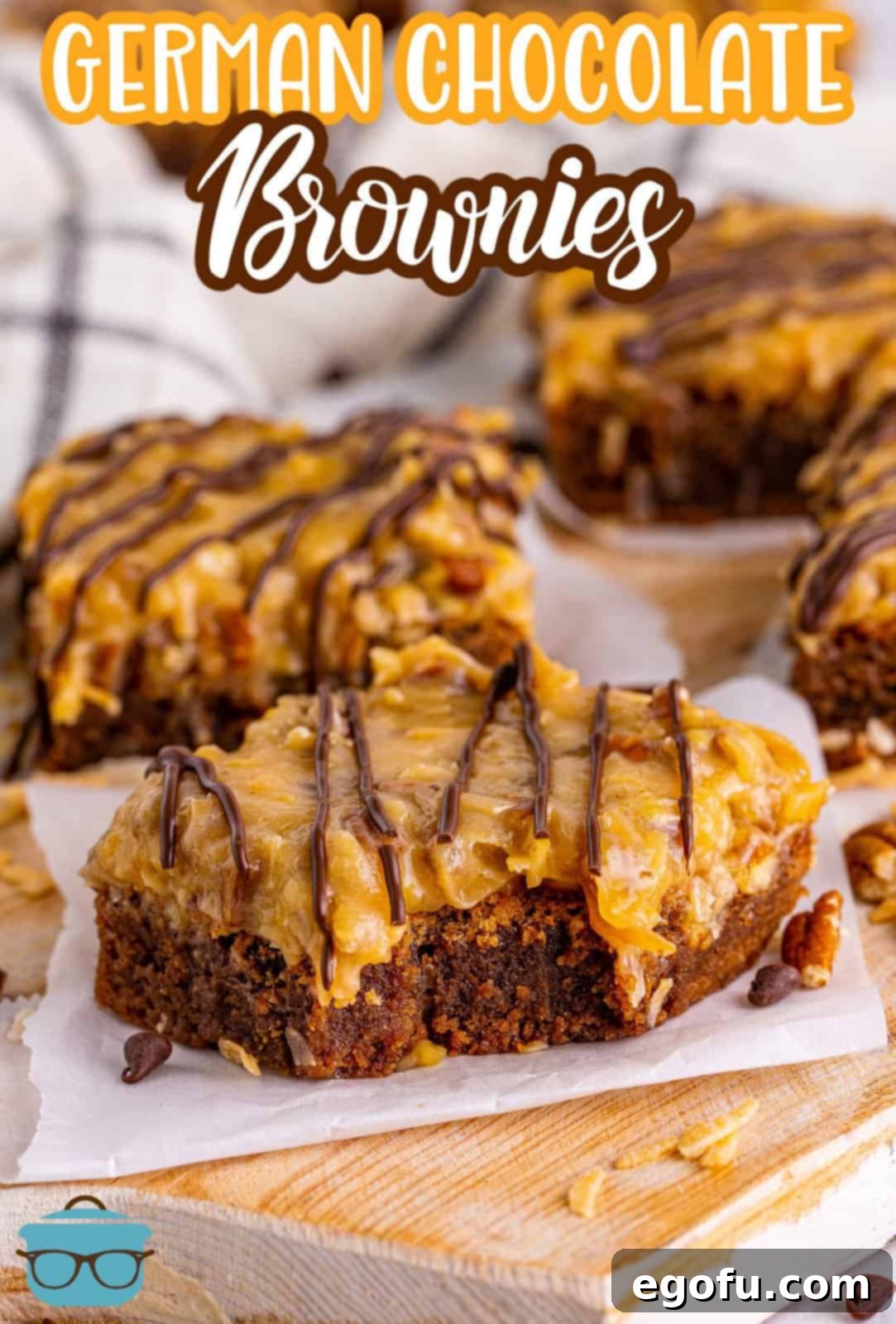 A top-down view of several German Chocolate Brownies arranged on parchment paper, with one piece having a bite taken out, highlighting the gooey frosting and fudgy base.