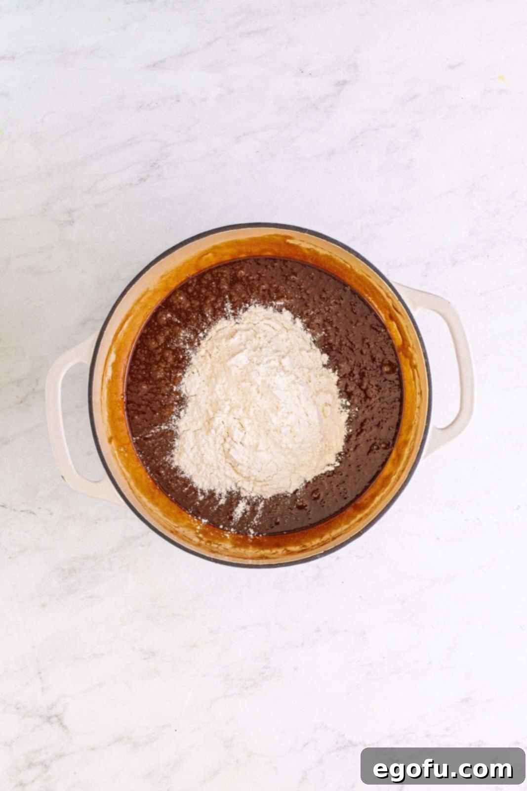 All-purpose flour added on top of the chocolate mixture in the pot, before mixing.