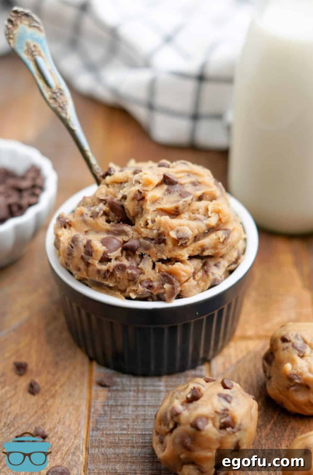 Choc-Chip Dough Delight 2 Edible Chocolate Chip Cookie Dough in black ramekin with spoon, invitingly ready to be scooped.