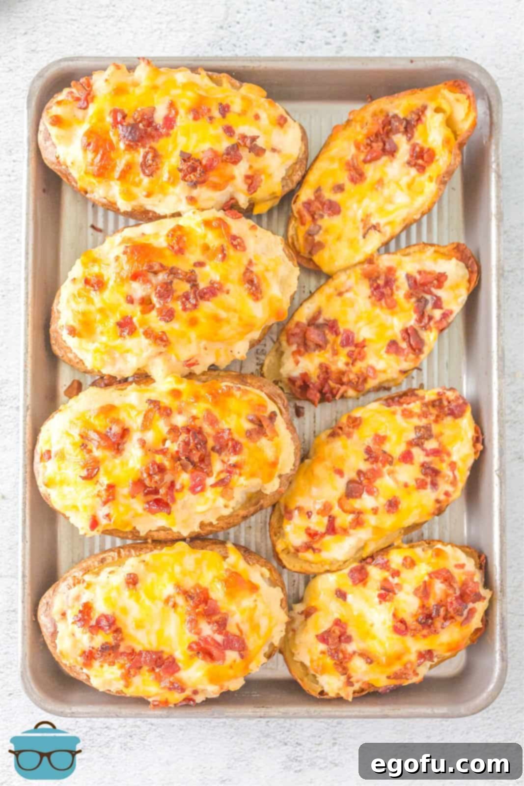 A metal tray full of finished Grilled Twice Baked Potatoes, ready to be served.
