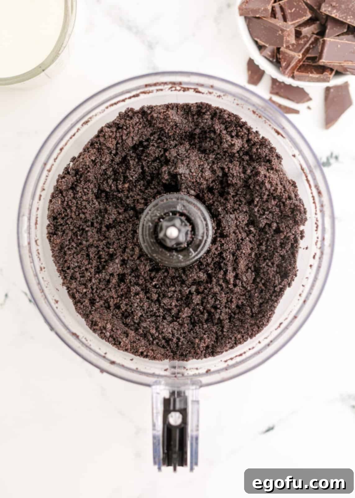 Oreos and butter mixed together in food processor, forming a cohesive crumb mixture.
