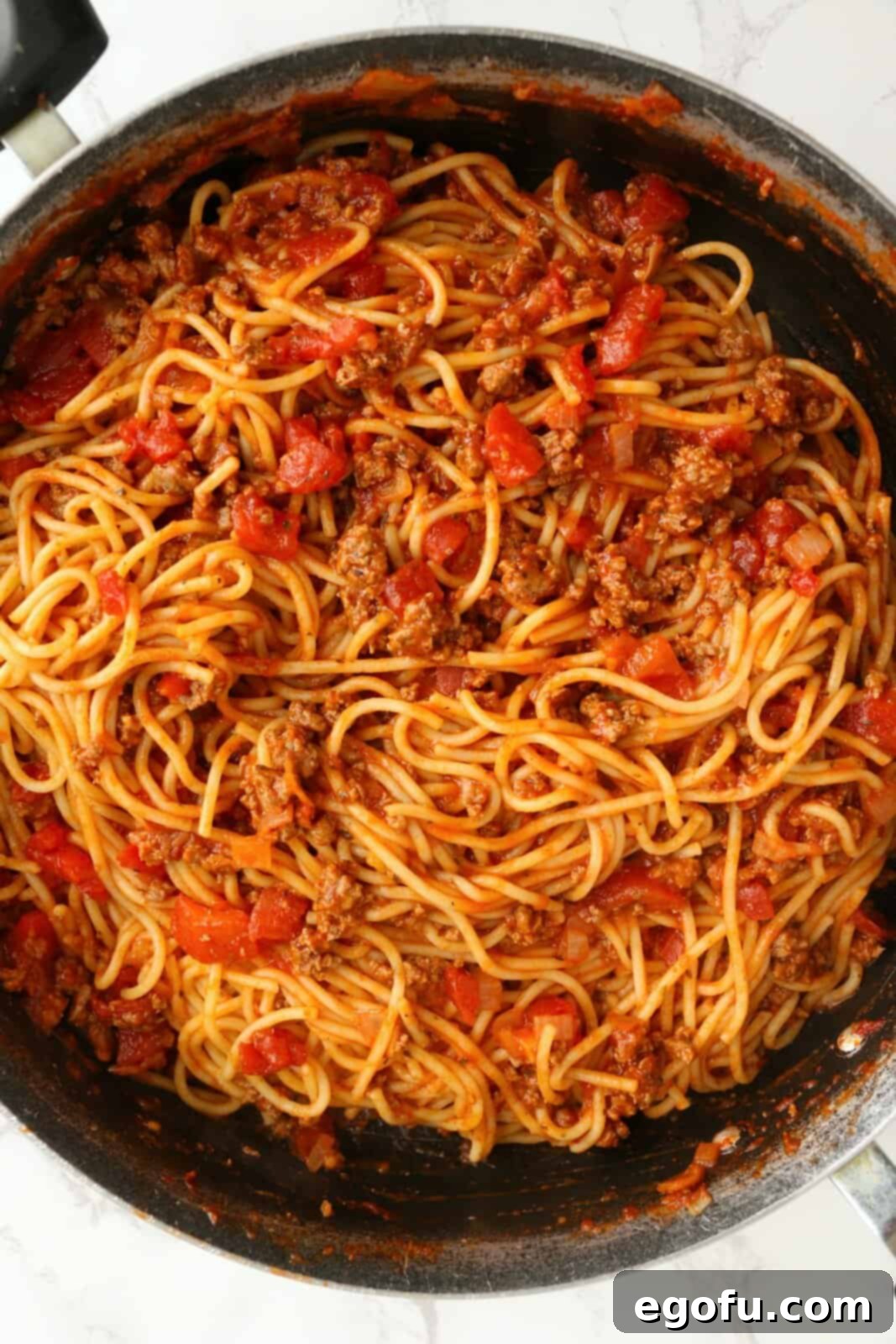 Our School's Spaghetti Day 11 Pasta stirred into meat sauce.