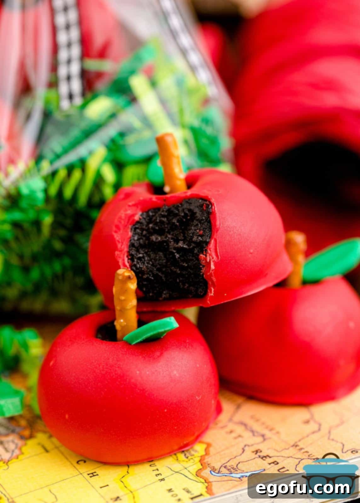 A stack of beautifully crafted Back-to-School Apple Shaped Oreo Truffles, with one showing a bite taken out, revealing the creamy Oreo center, enticing and delicious.