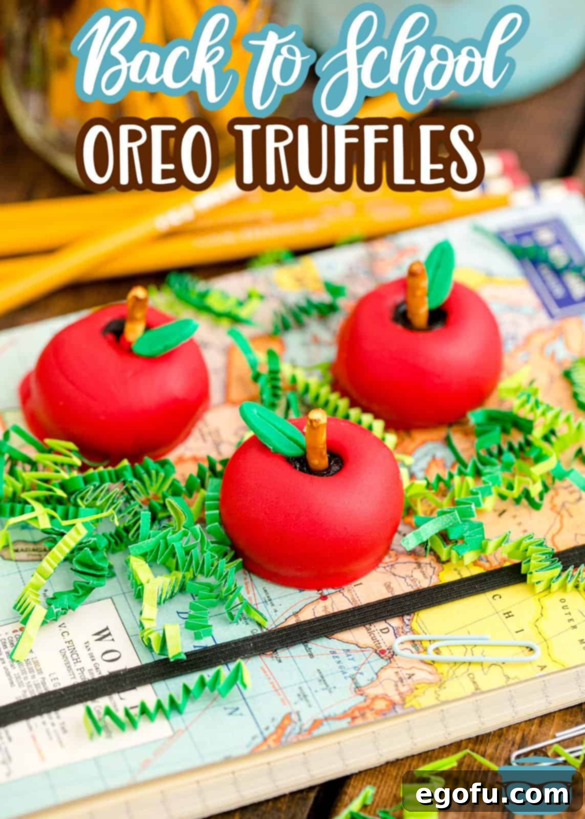 Three beautifully decorated Back-to-School Apple Shaped Oreo Truffles resting on a vintage map, perfect for a Pinterest share and a sweet start to the school year.