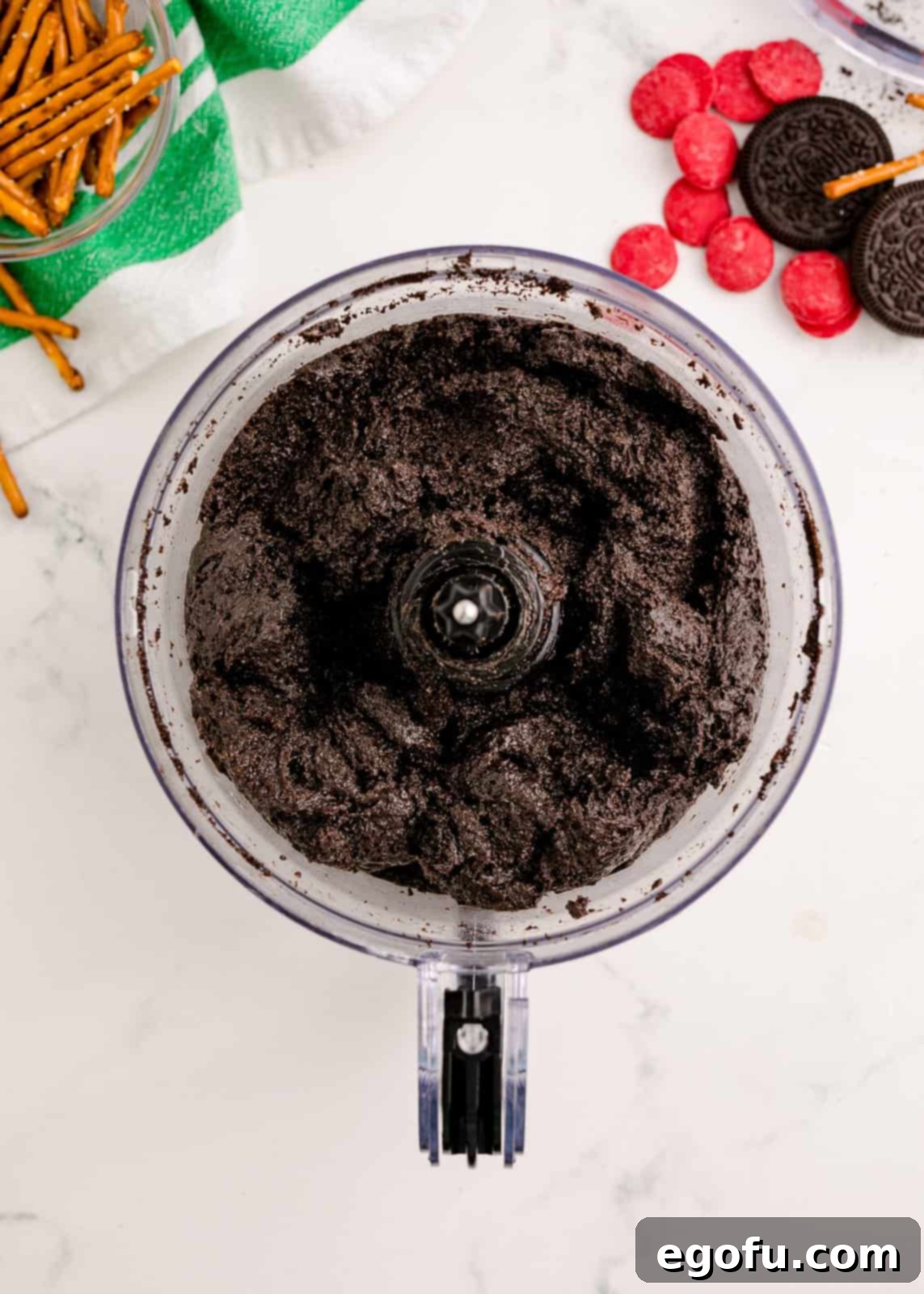 Oreo crumbs, softened cream cheese, butter, and vanilla extract blended together in a food processor, forming the creamy truffle mixture base.