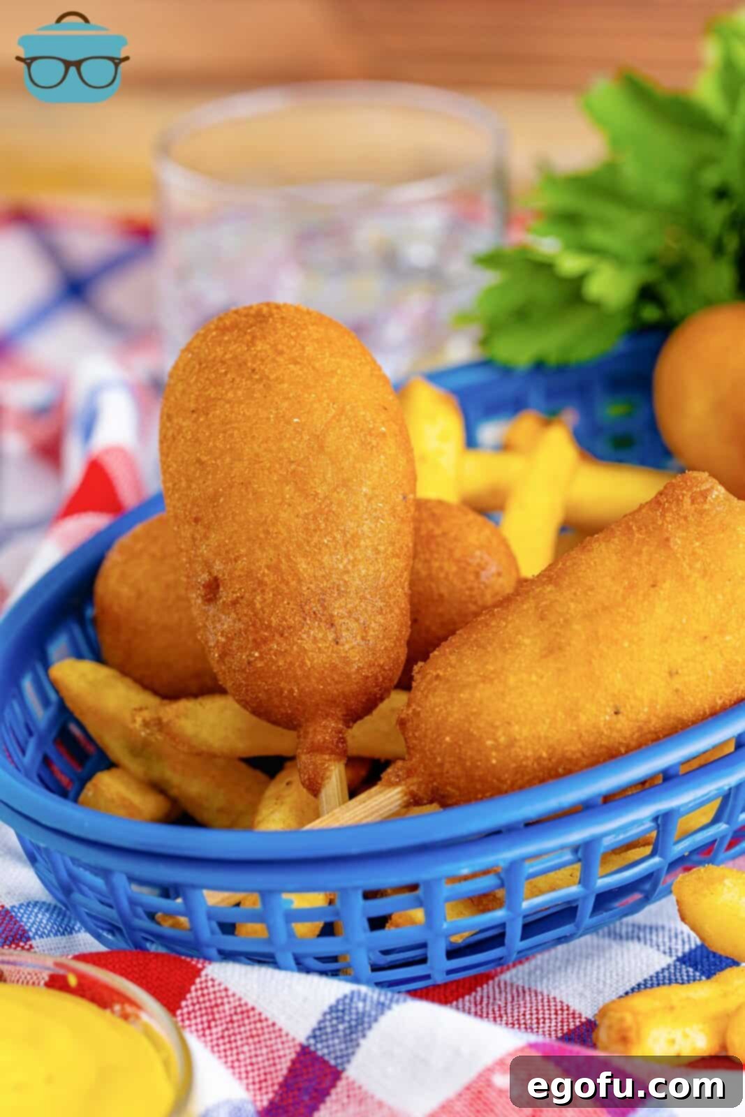 Mini Homemade Corn Dogs in blue basket on top of French fries.