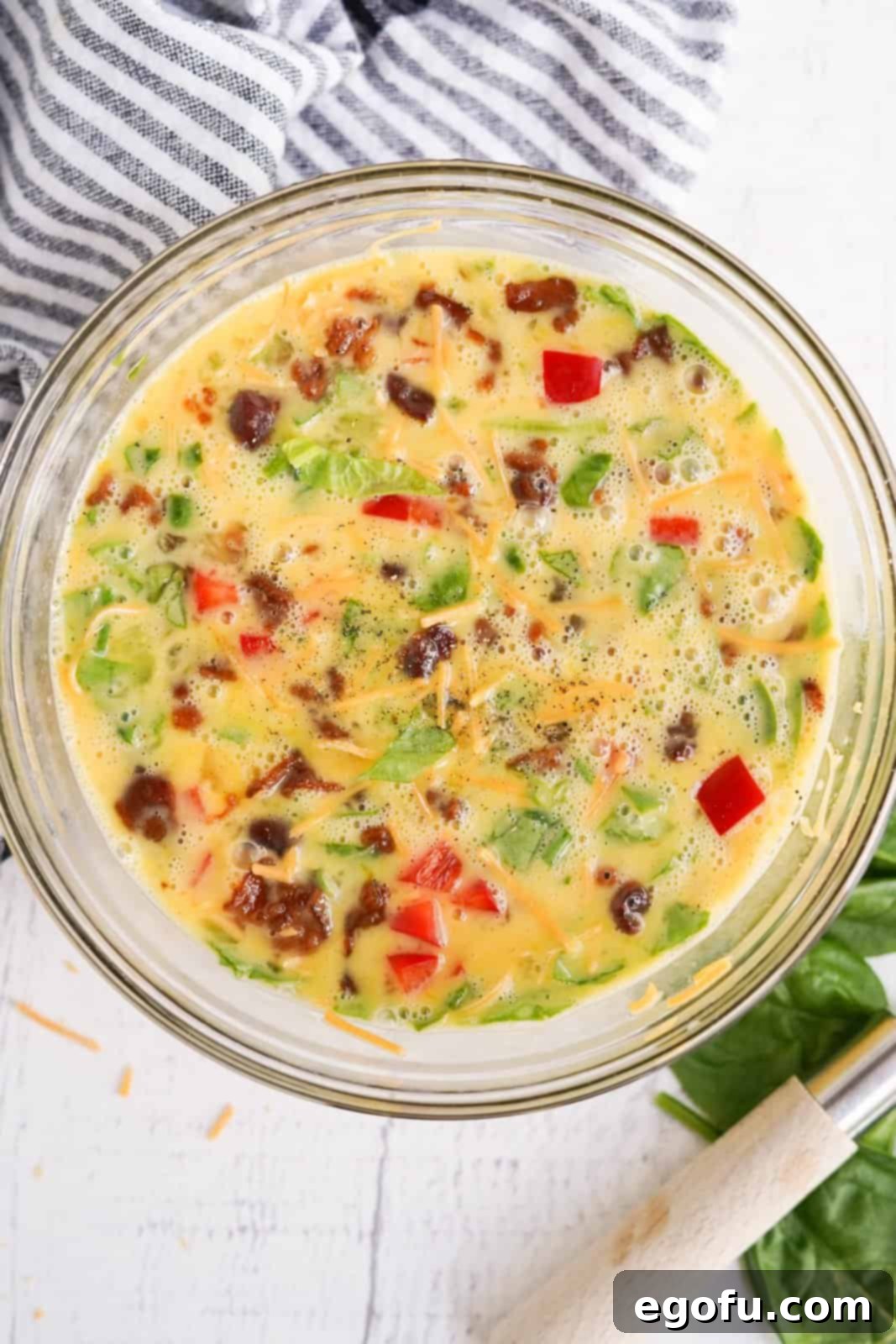 Shredded cheese, red bell pepper, spinach, bacon, salt and pepper stirred into the eggs.