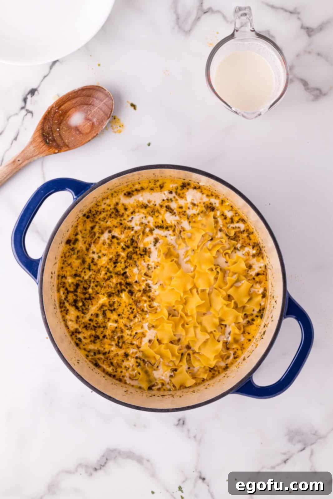 Cream cheese and pasta added to dutch oven.