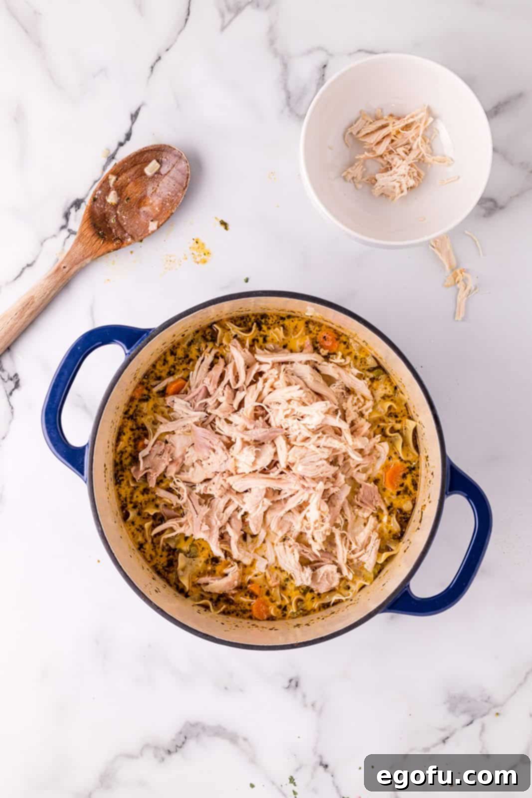 Shredded chicken added to dutch oven.