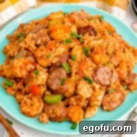 Close up square image of Louisiana Jambalaya on a blue plate, garnished with green onions.