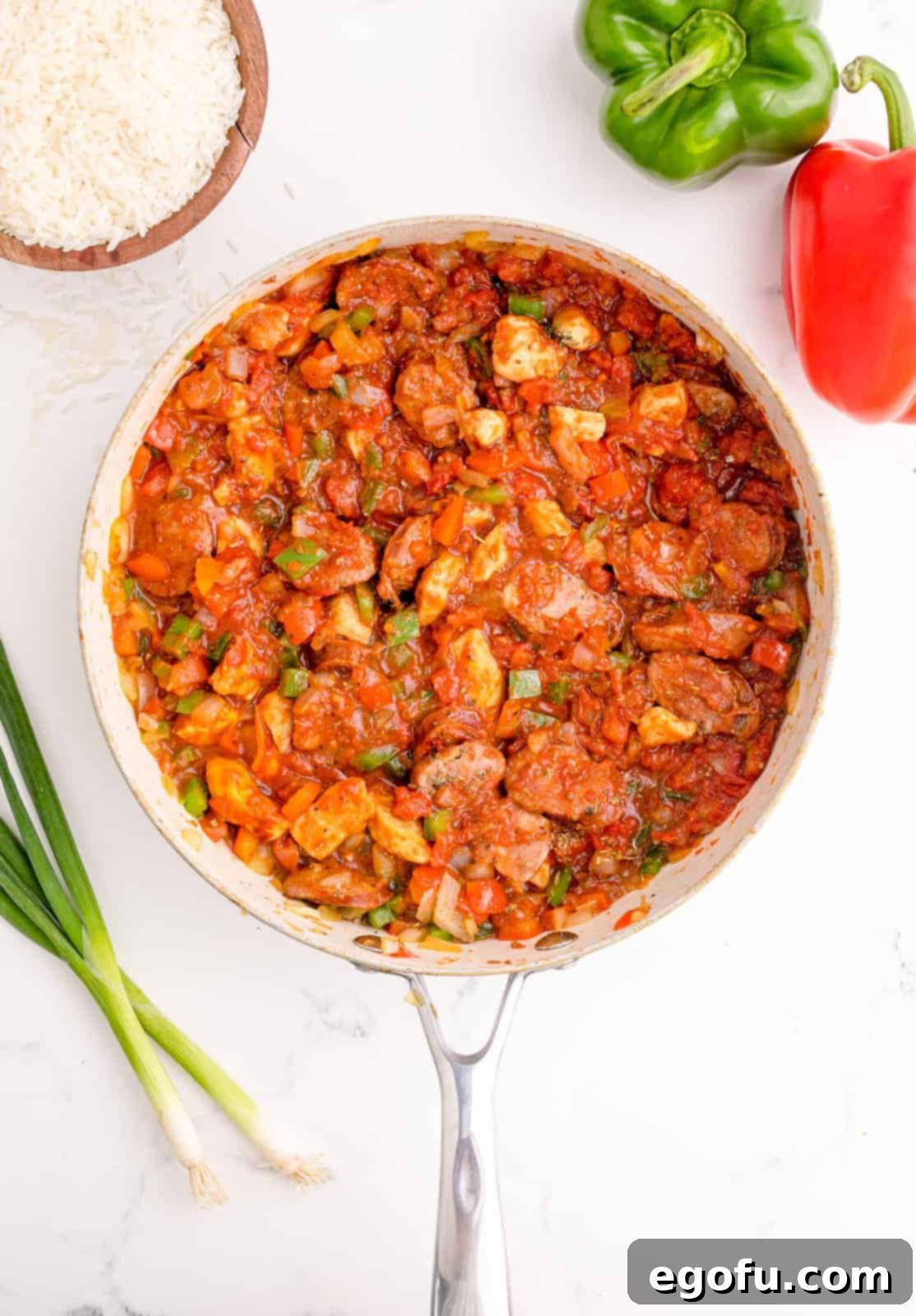 Crushed tomatoes and a blend of spices (paprika, salt, cumin, oregano, basil, thyme, pepper, cayenne pepper) added to the meat and vegetable mixture and stirred thoroughly.