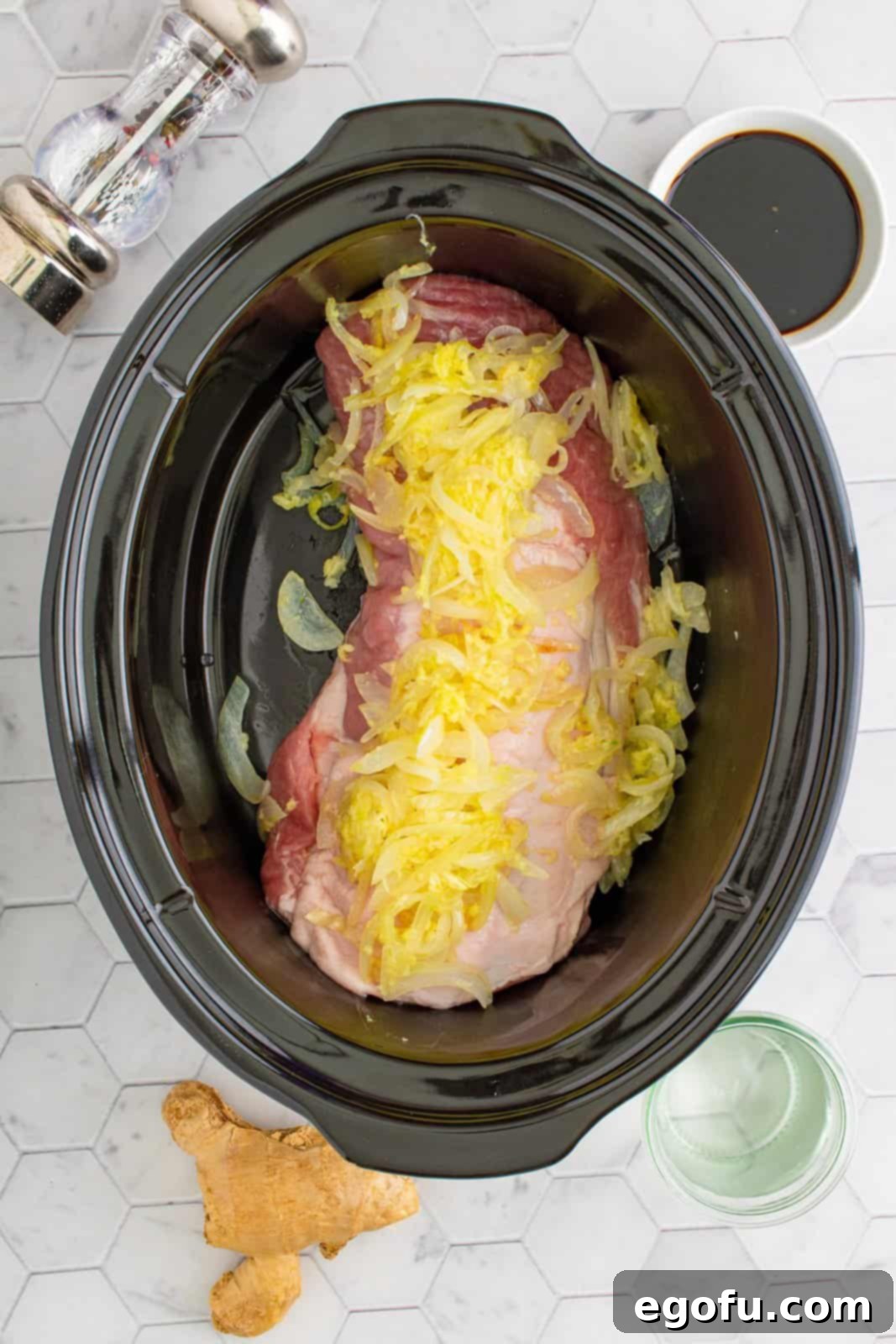 Effortless Crock Pot Pork Loin 5 Pork loin in crock pot with sautéed onions on top.