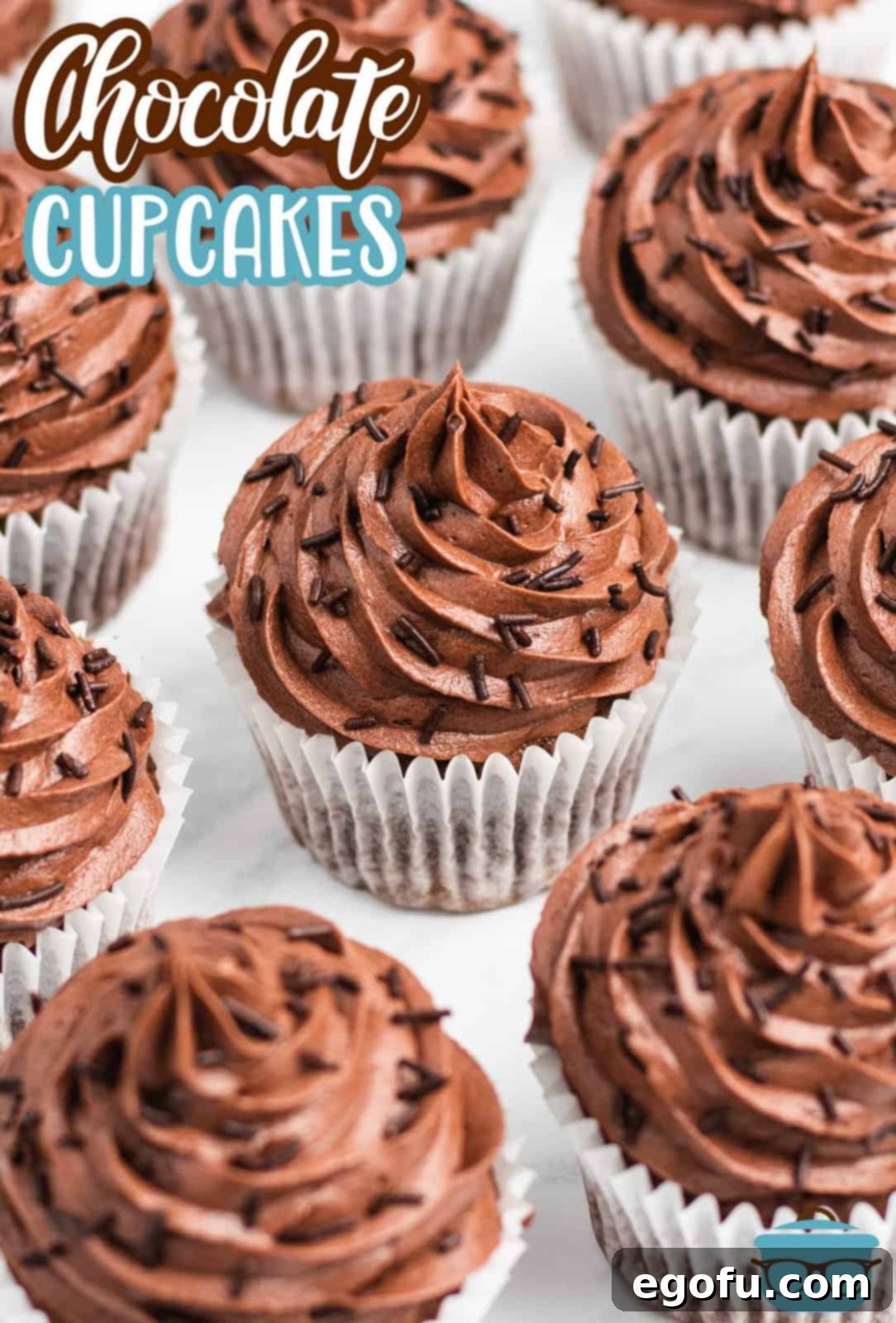 Pinterest image slightly overhead of Easy Chocolate Cupcakes on marble showing sprinkle garnishes.