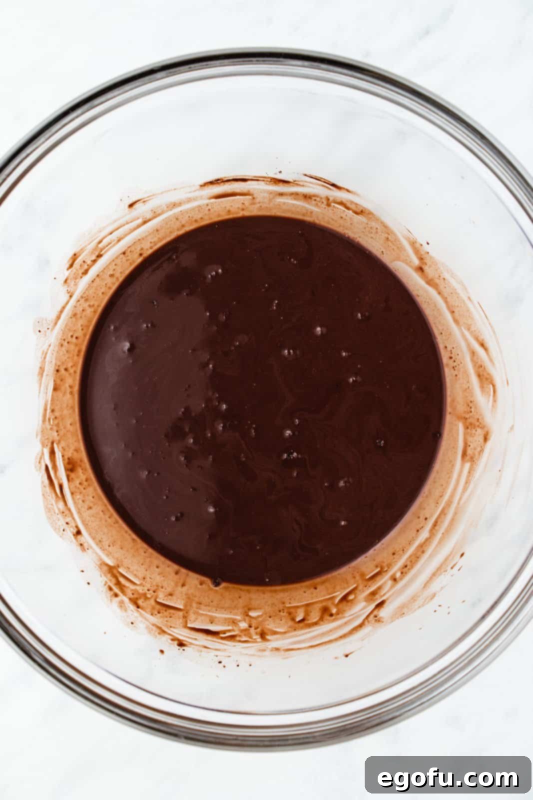 Cocoa powder and boiling water mixed together in bowl.