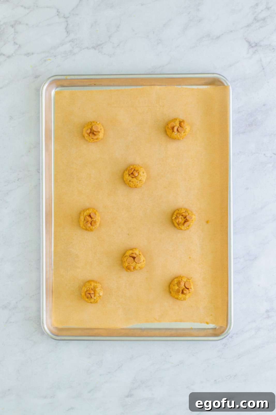 Peanut Butter Oat Cookie Bliss 13 Dough balls with peanut butter chips on parchment lined baking sheet.