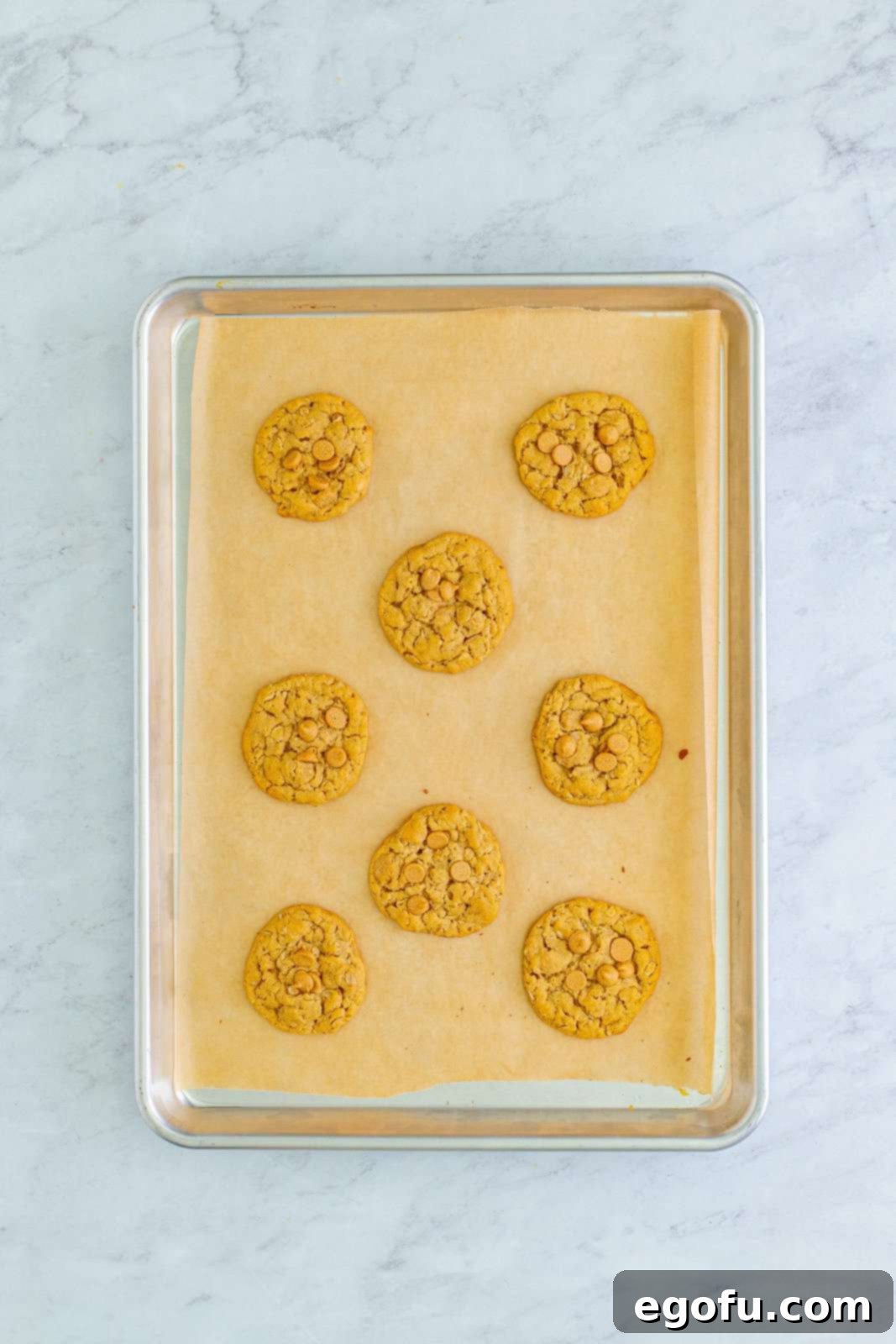 Peanut Butter Oat Cookie Bliss 14 Baked cookies on parchment lined baking sheet.