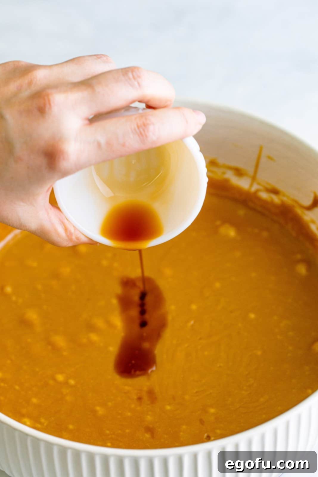 Golden Southern Caramel Delight 17 Vanilla being added to caramel mixture in bowl.