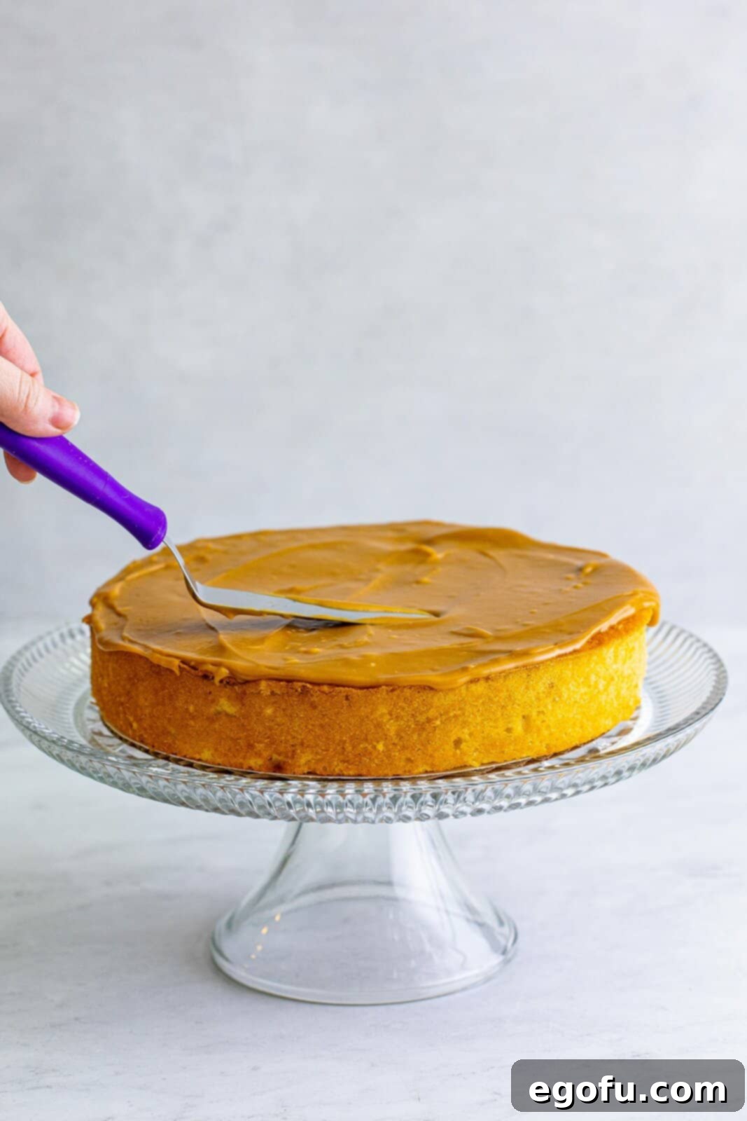 Golden Southern Caramel Delight 18 One cake layer being spread with caramel frosting.