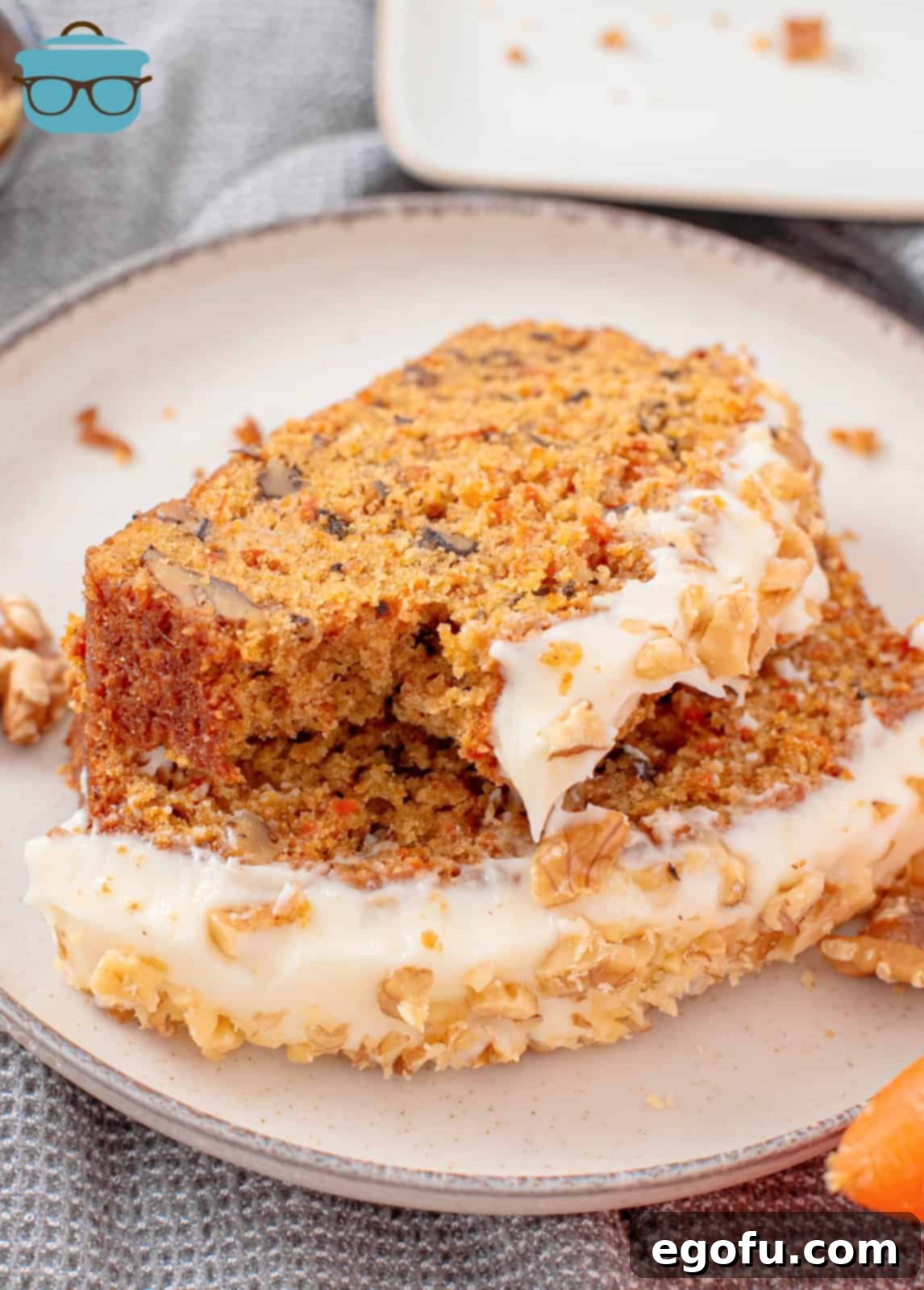 Two slices of the Carrot Cake Loaf on plate with bite taken out of top one.