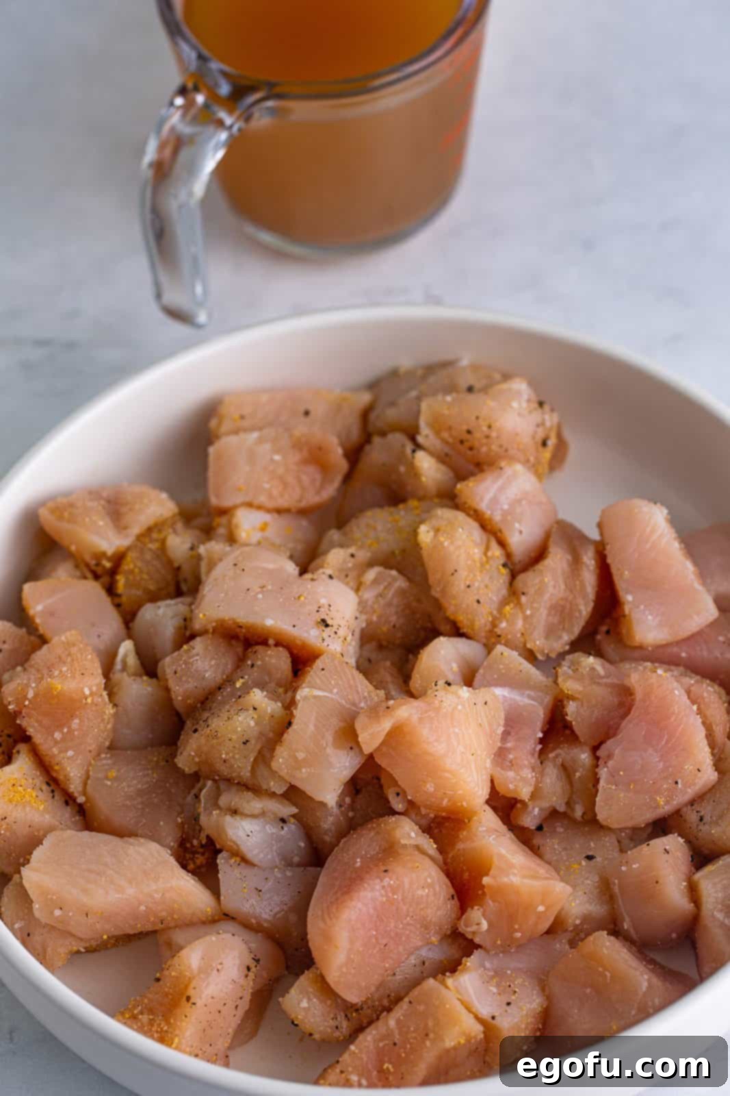 Seasoned chicken on plate, showing pieces coated with spices.