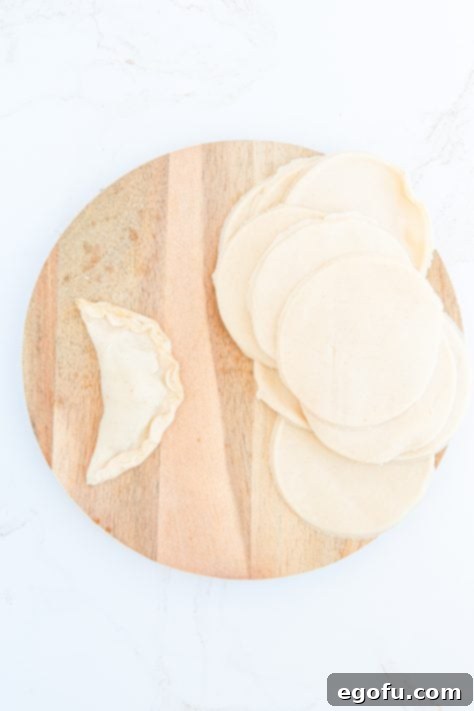 Hand pies folded together on wooden board.