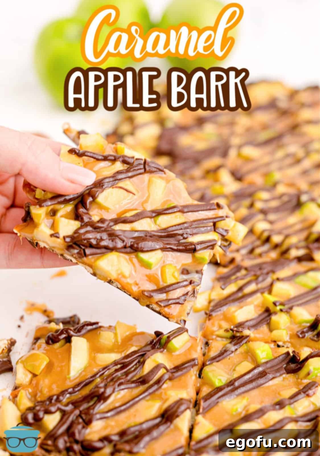A hand holding a piece of golden Caramel Apple Bark, ready to be enjoyed.