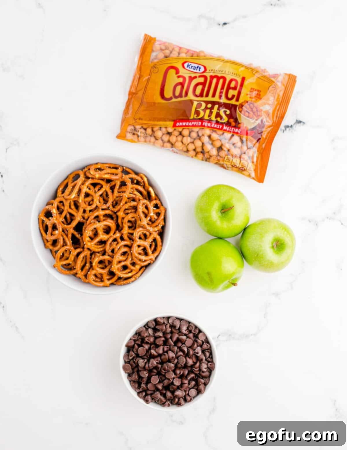Key ingredients for Caramel Apple Bark: crisp apples, semi-sweet chocolate chips, crunchy pretzels, and soft caramel bits.