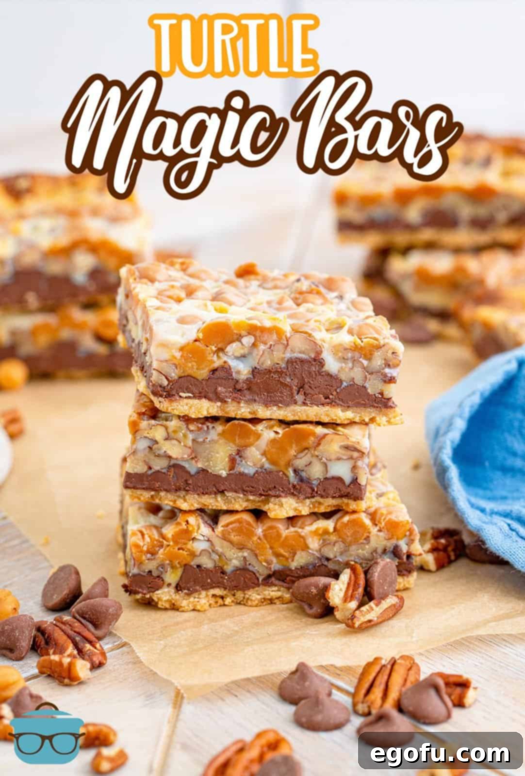 Pinterest image of three stacked Turtle Magic Bars on wooden board with chocolate chips and nuts in front, illustrating their deliciousness.