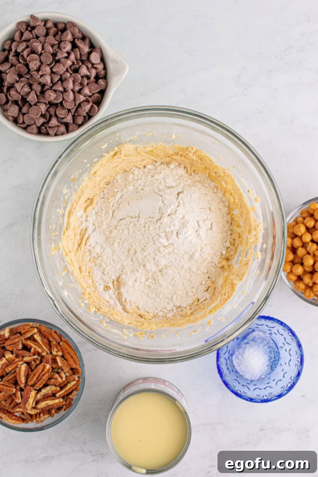 Flour added to the butter and sugar mixture, ready to be combined.