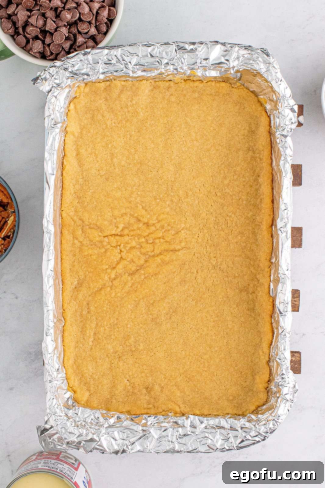 The baked and lightly golden brown crust in the pan, ready for its toppings.