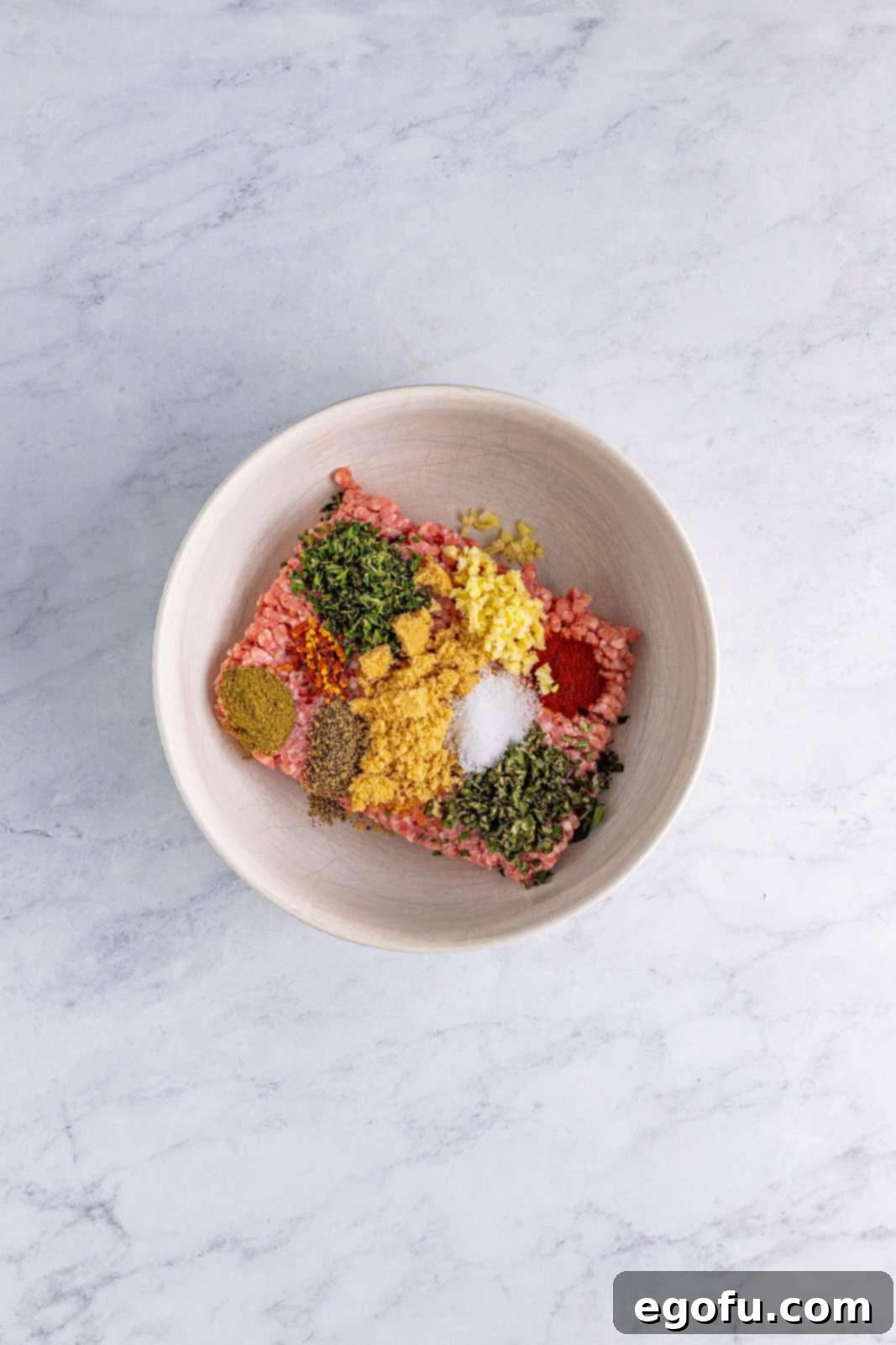 Ground pork and seasonings in bowl.