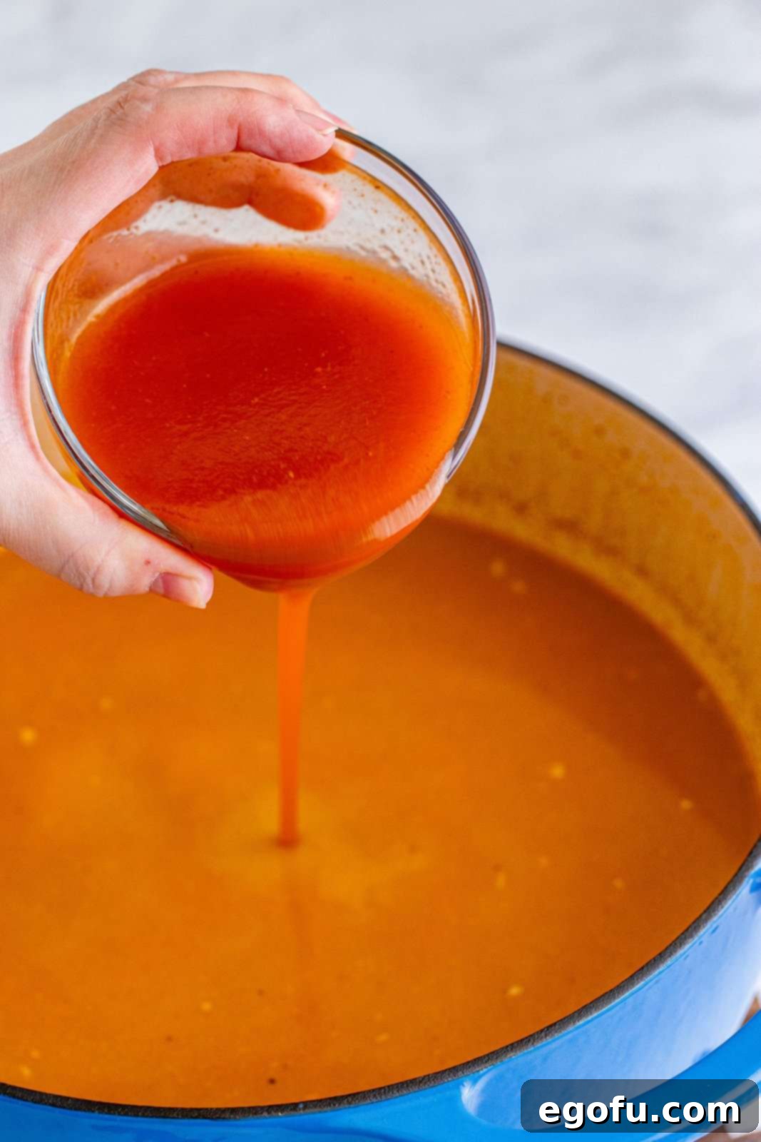 Southwest Chicken Enchilada Bowl 11 Enchilada sauce being poured into dutch oven.