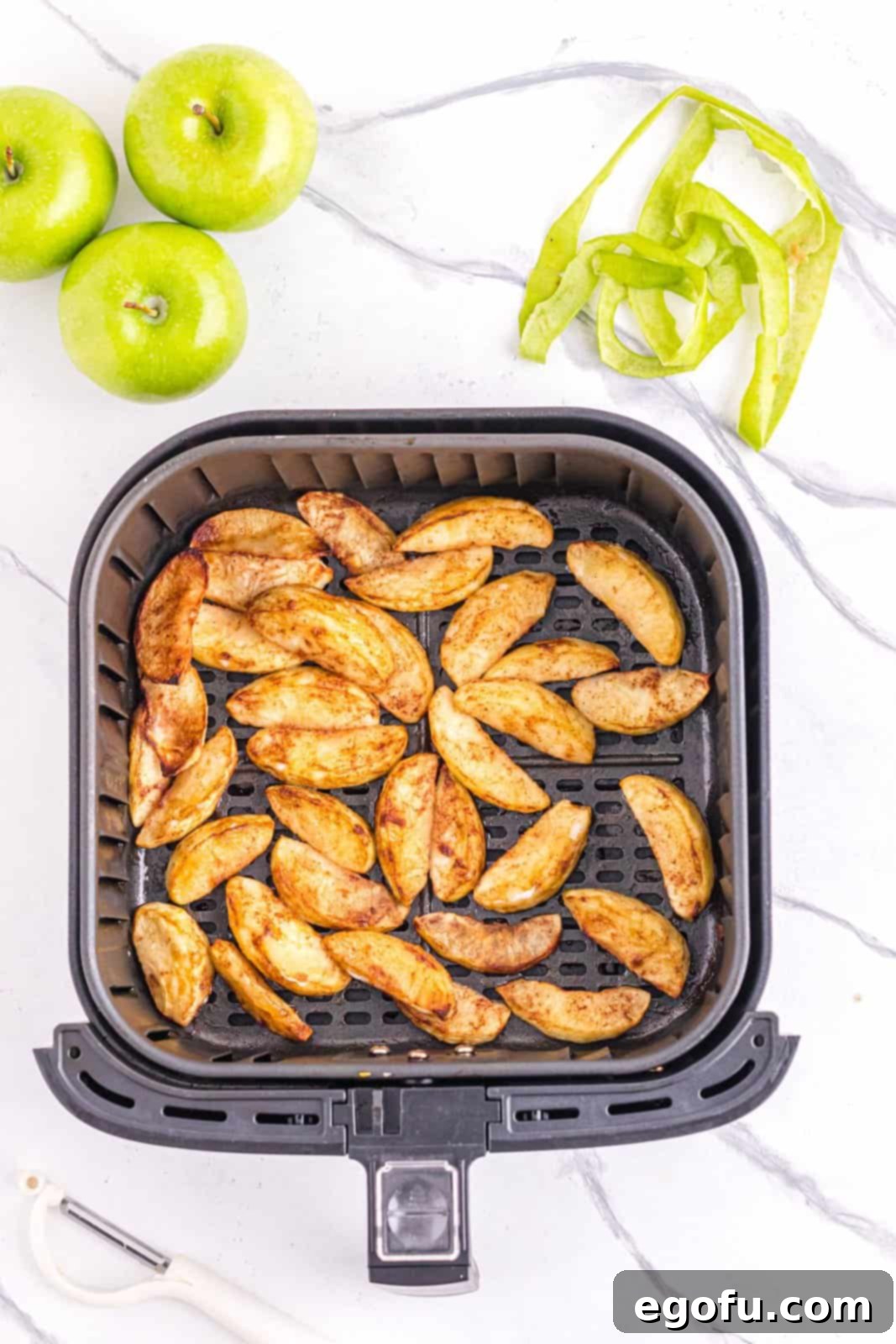 Finished apples in air fryer basket, showcasing their perfectly cooked, golden appearance.