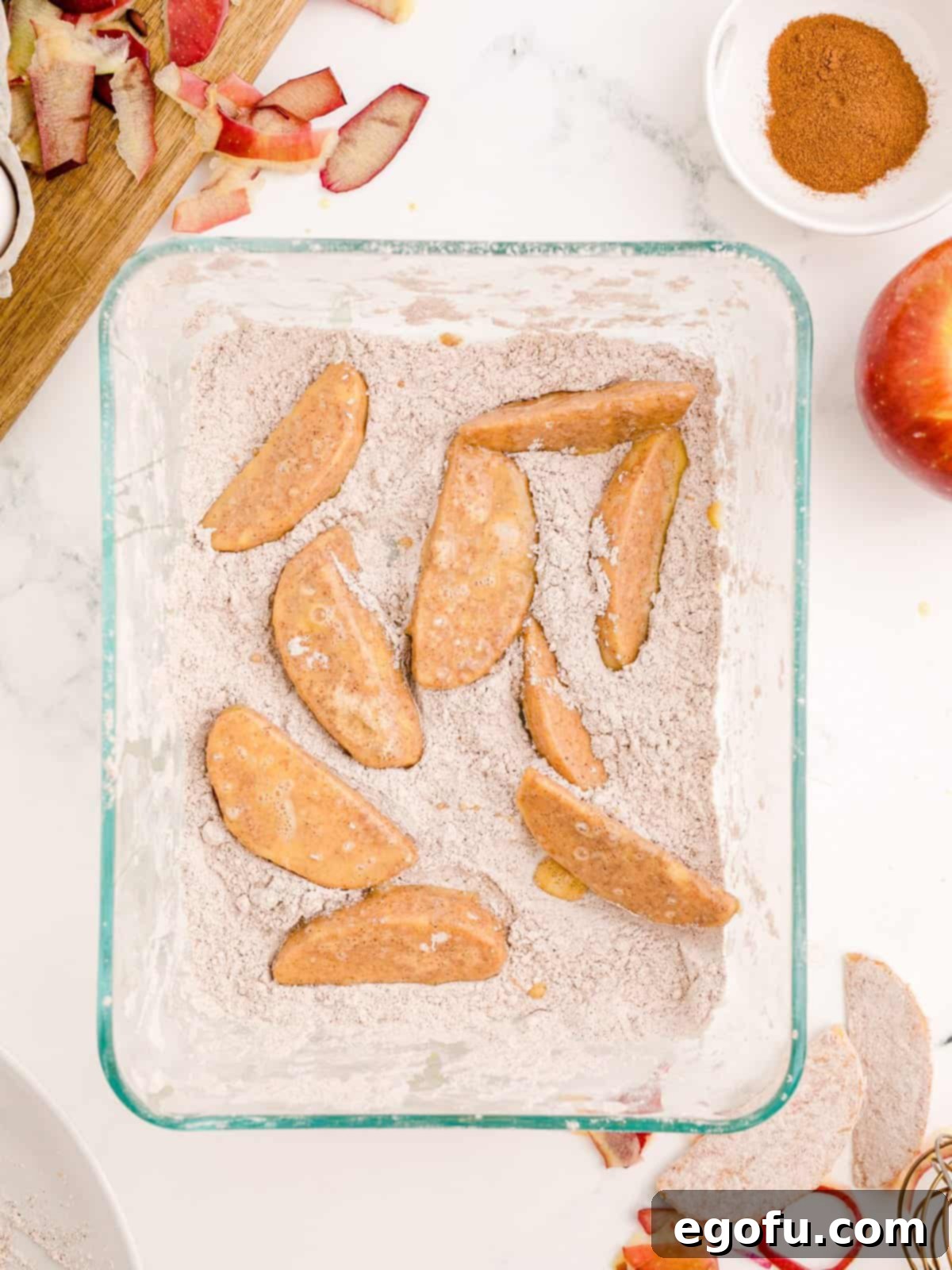Coated apples placed back into flour mixture.