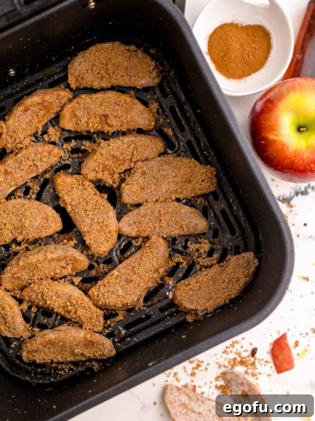 Finished apples in air fryer basket.