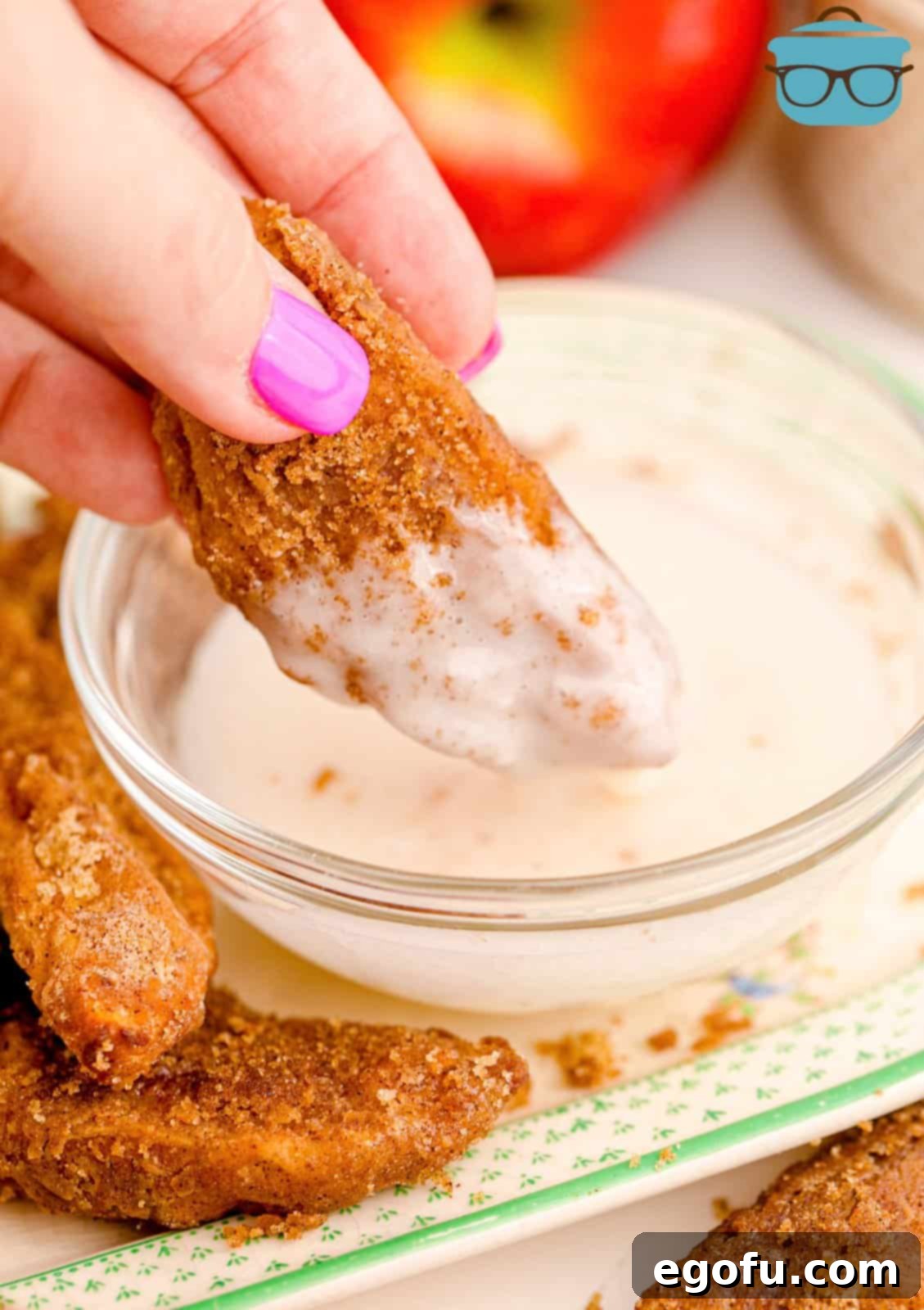 Hand dipping one of the Air Fryer Apple Fries into a dipping sauce.