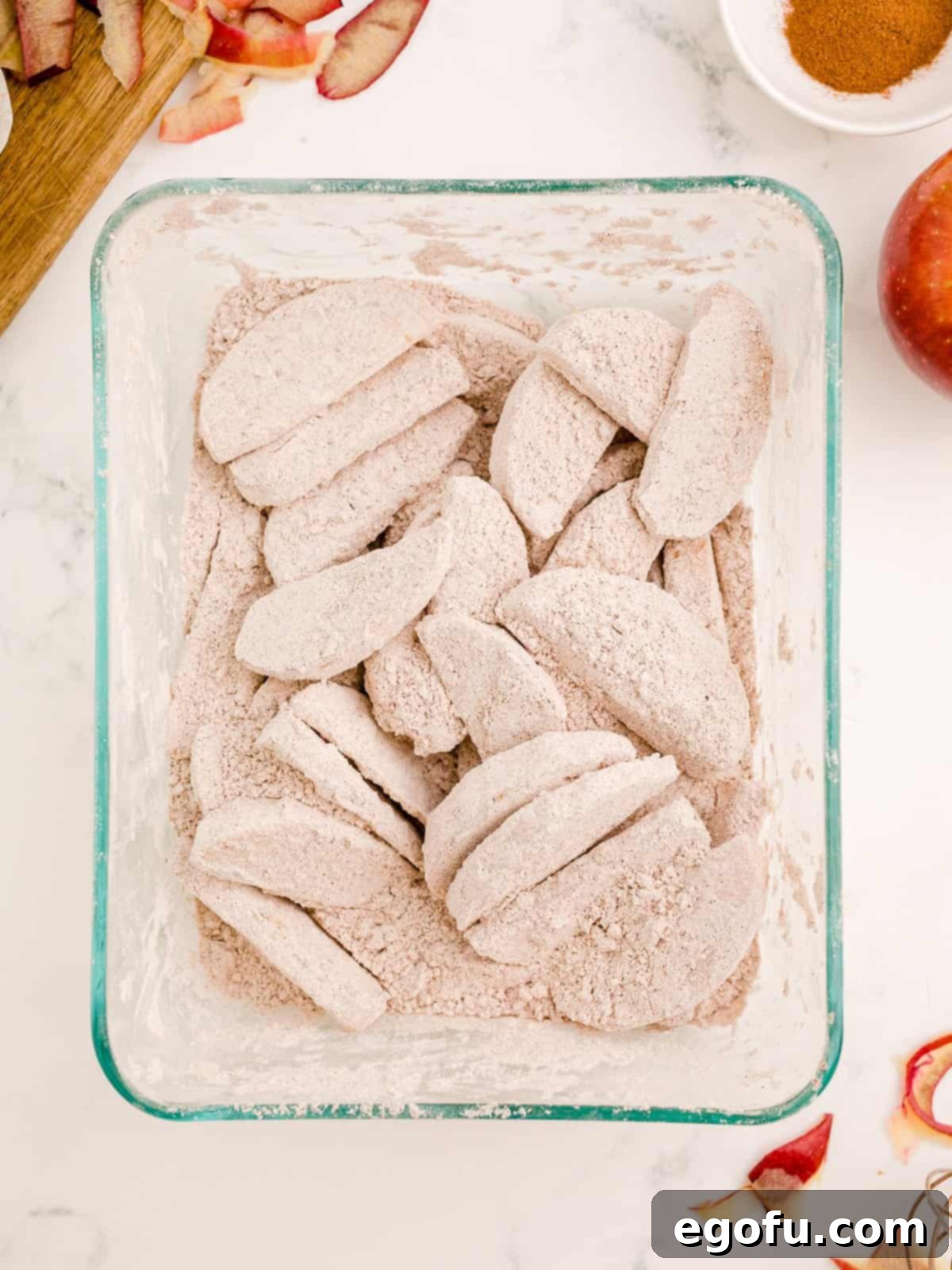 Apples coated in flour mixture in container.