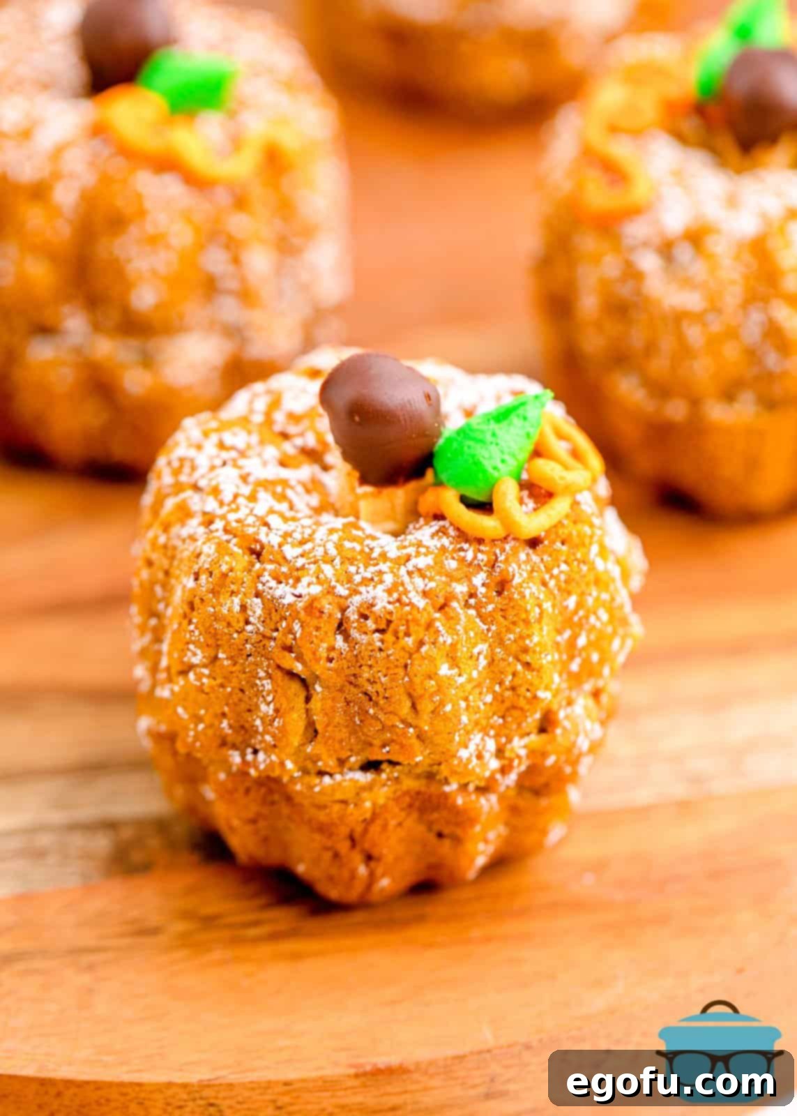 Close up of Mini Pumpkin Bundt Cakes on wooden cutting board.