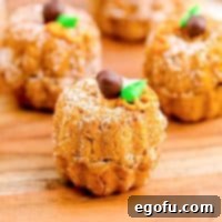 Close up square image of Mini Pumpkin Bundt Cake on wooden board.