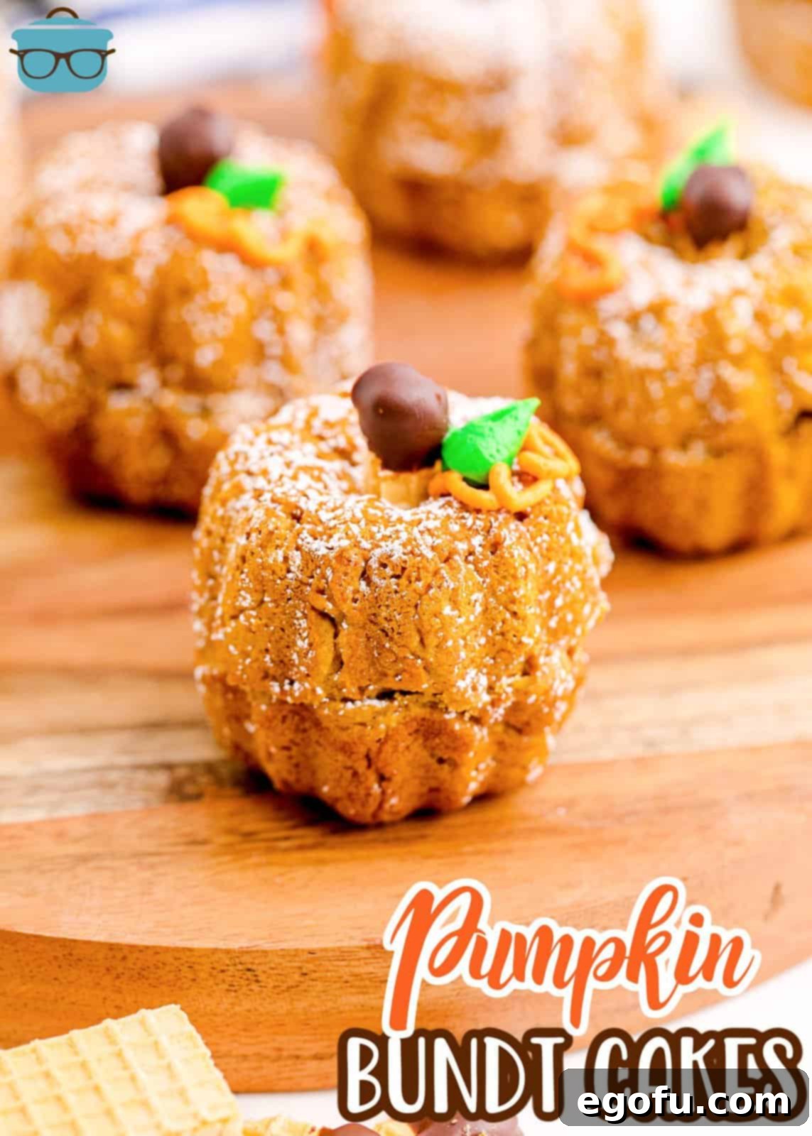 Pinterest image of Mini Pumpkin Bundt Cakes on wooden platter showing decorations.