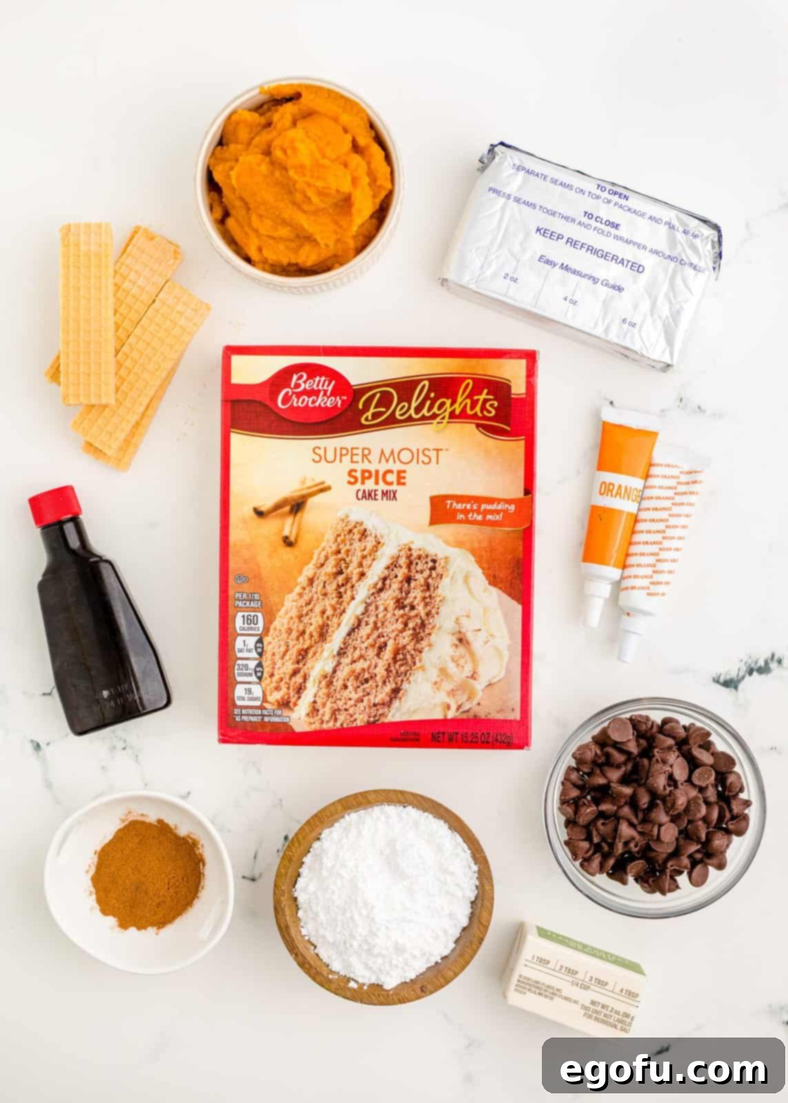 Ingredients needed: spice cake mix, pumpkin puree, cinnamon, cream cheese, Orange and Green food coloring, salted butter, vanilla extract, powdered sugar, wafer cookies and semi-sweet chocolate chips.