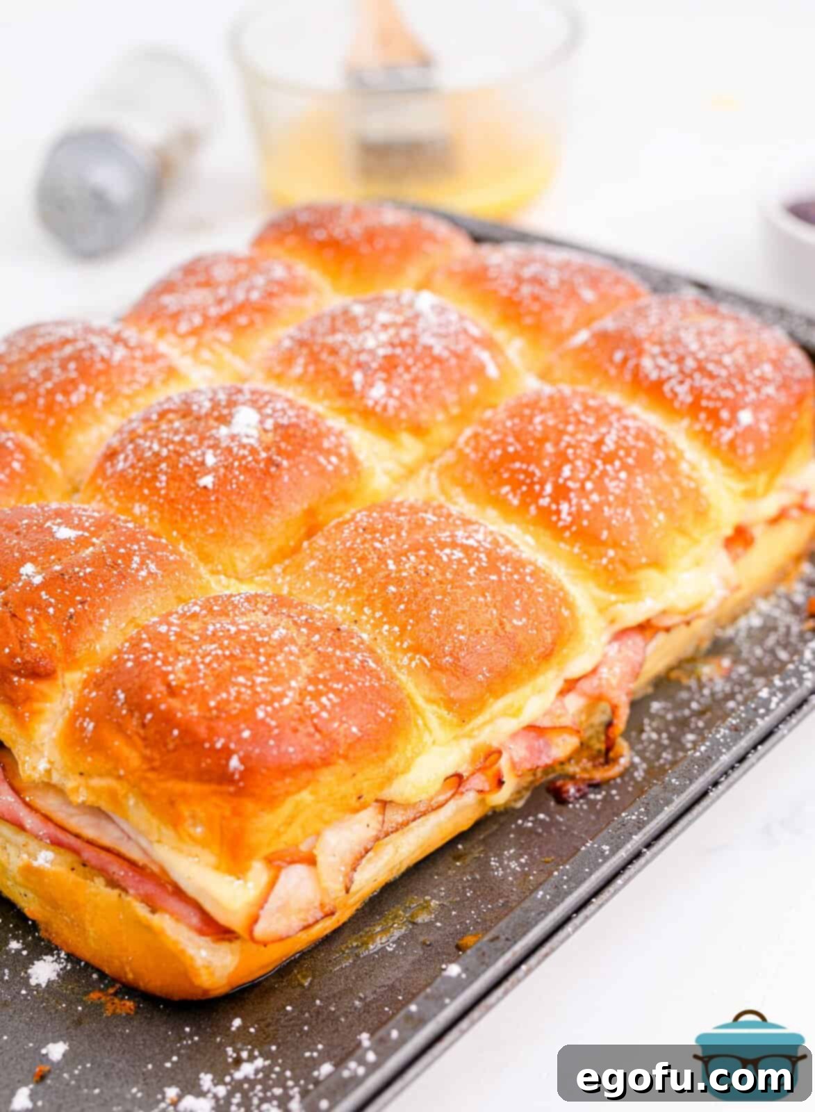 Finished Monte Cristo Sliders on pan, topped with powdered sugar.