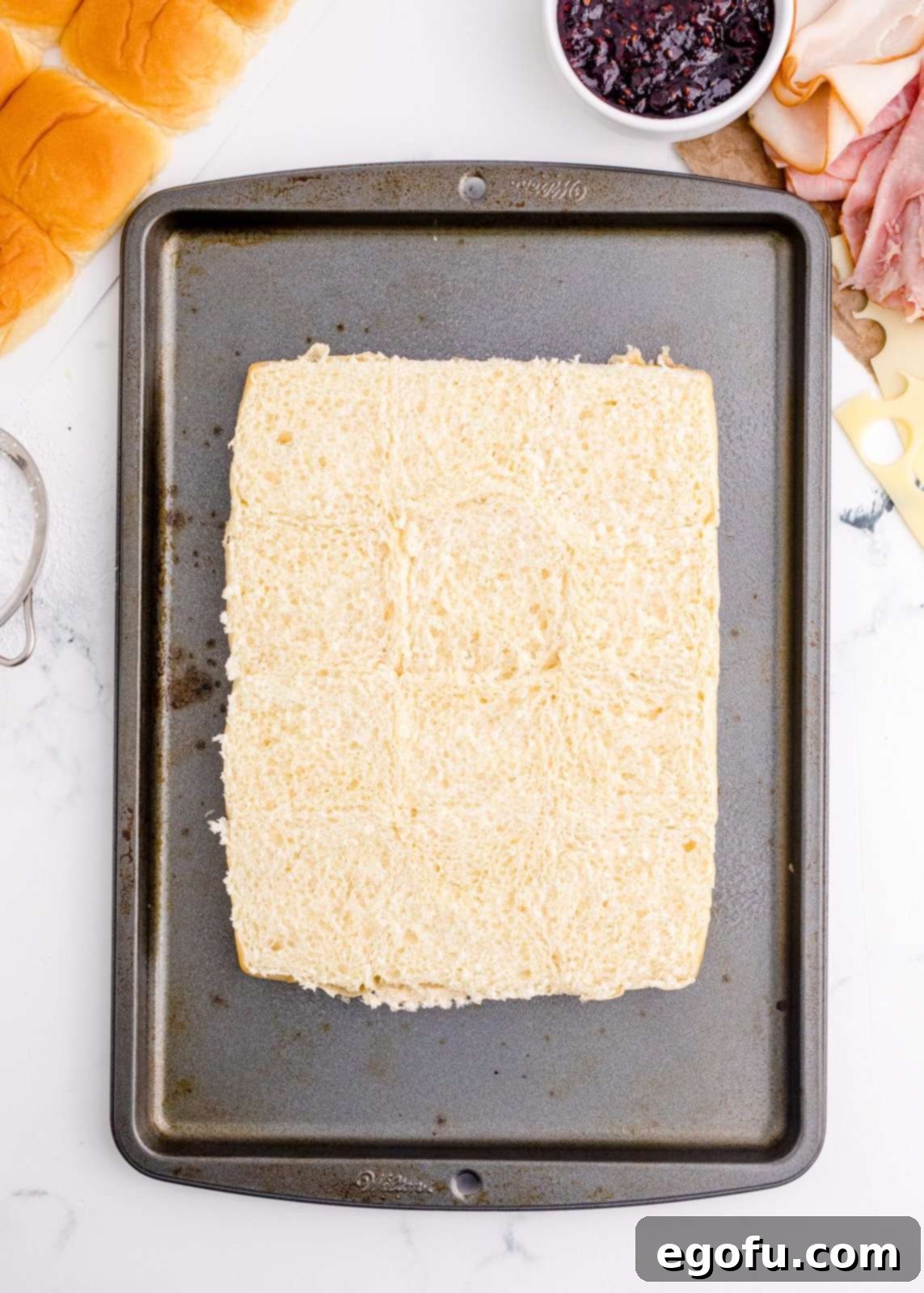 Bottom of Hawaiian rolls on baking pan.